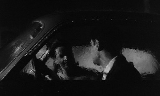 Still from Antonioni’s La notte showing Lidia inside a car on a rainy night.