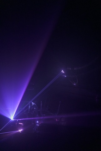 A purple laser scatters its beam through a dark room